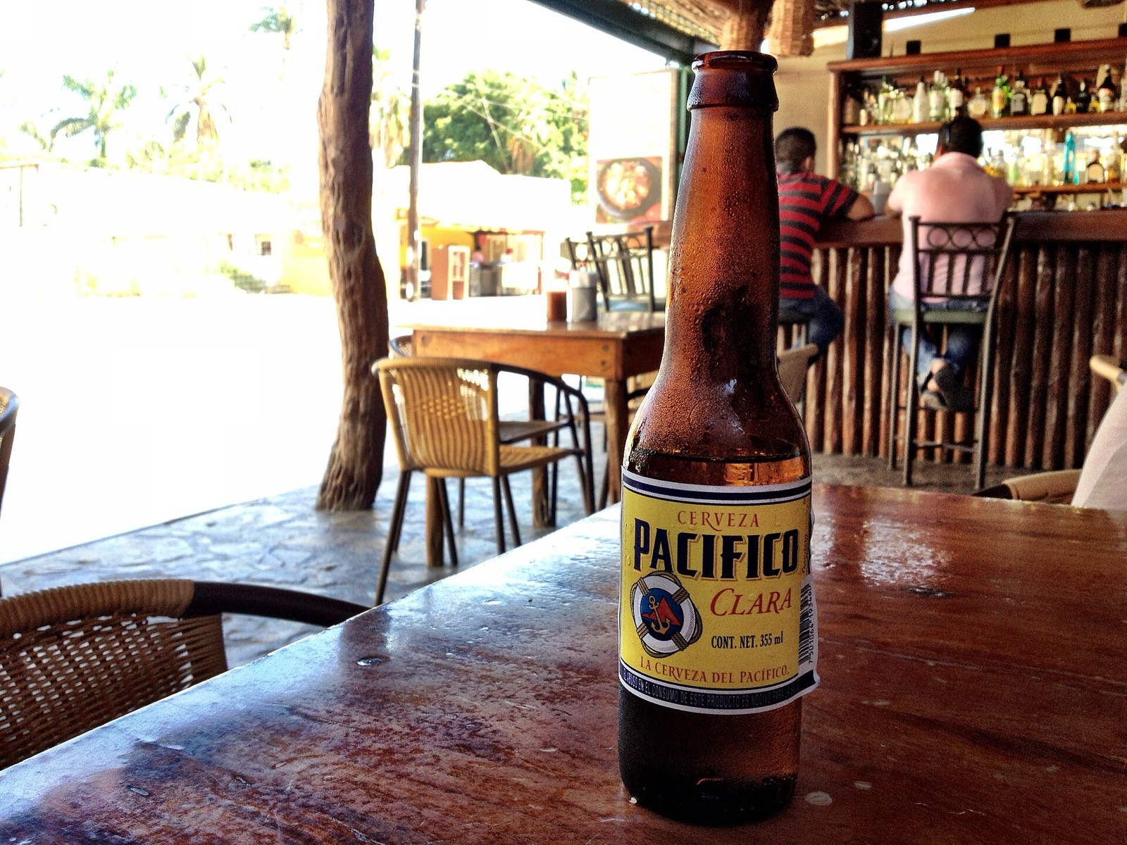 Bottle of Pacifico beer on a wooden table at an open-air taco bar in Cabo San Lucas