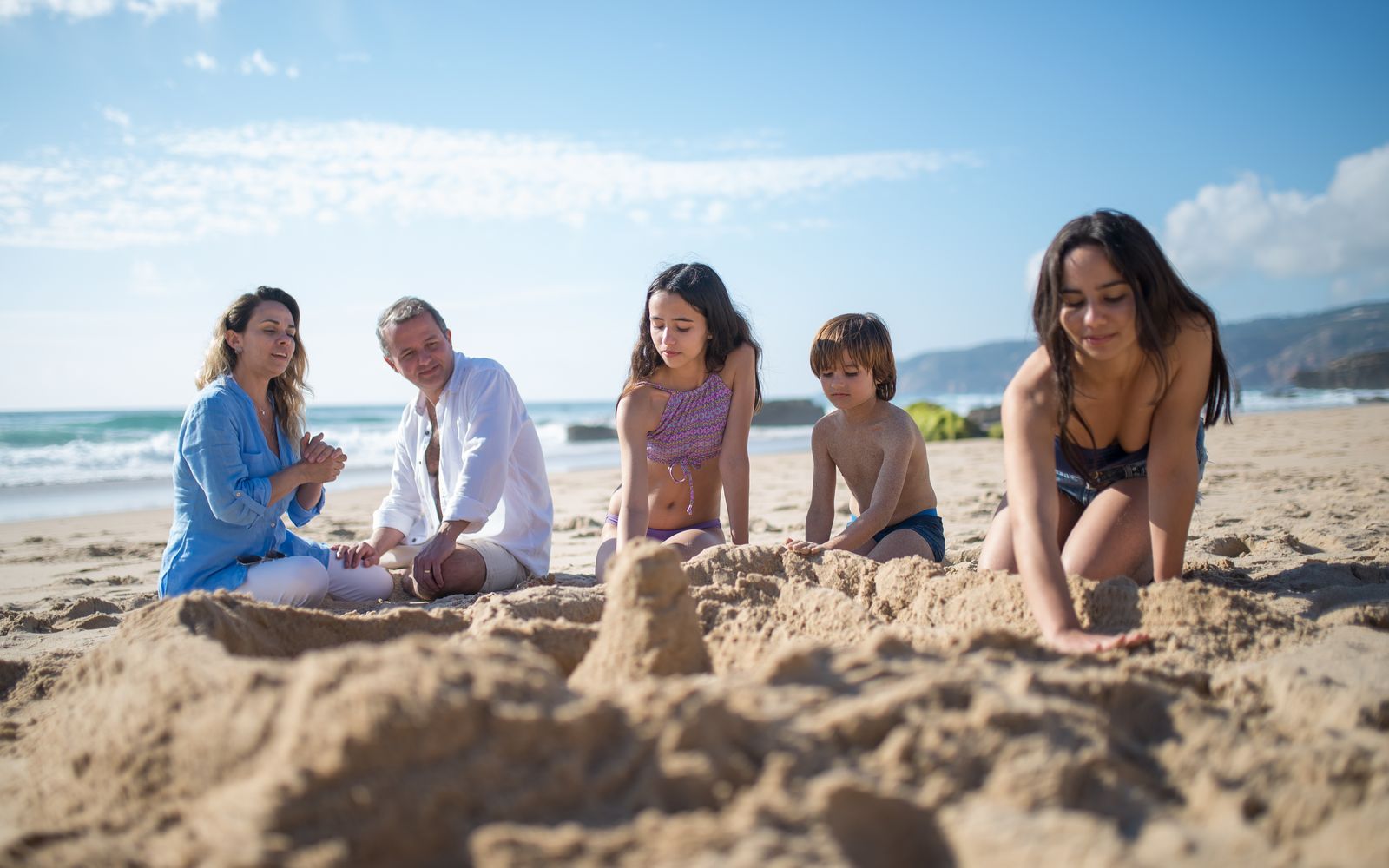 A family building sandcastles on the beach
