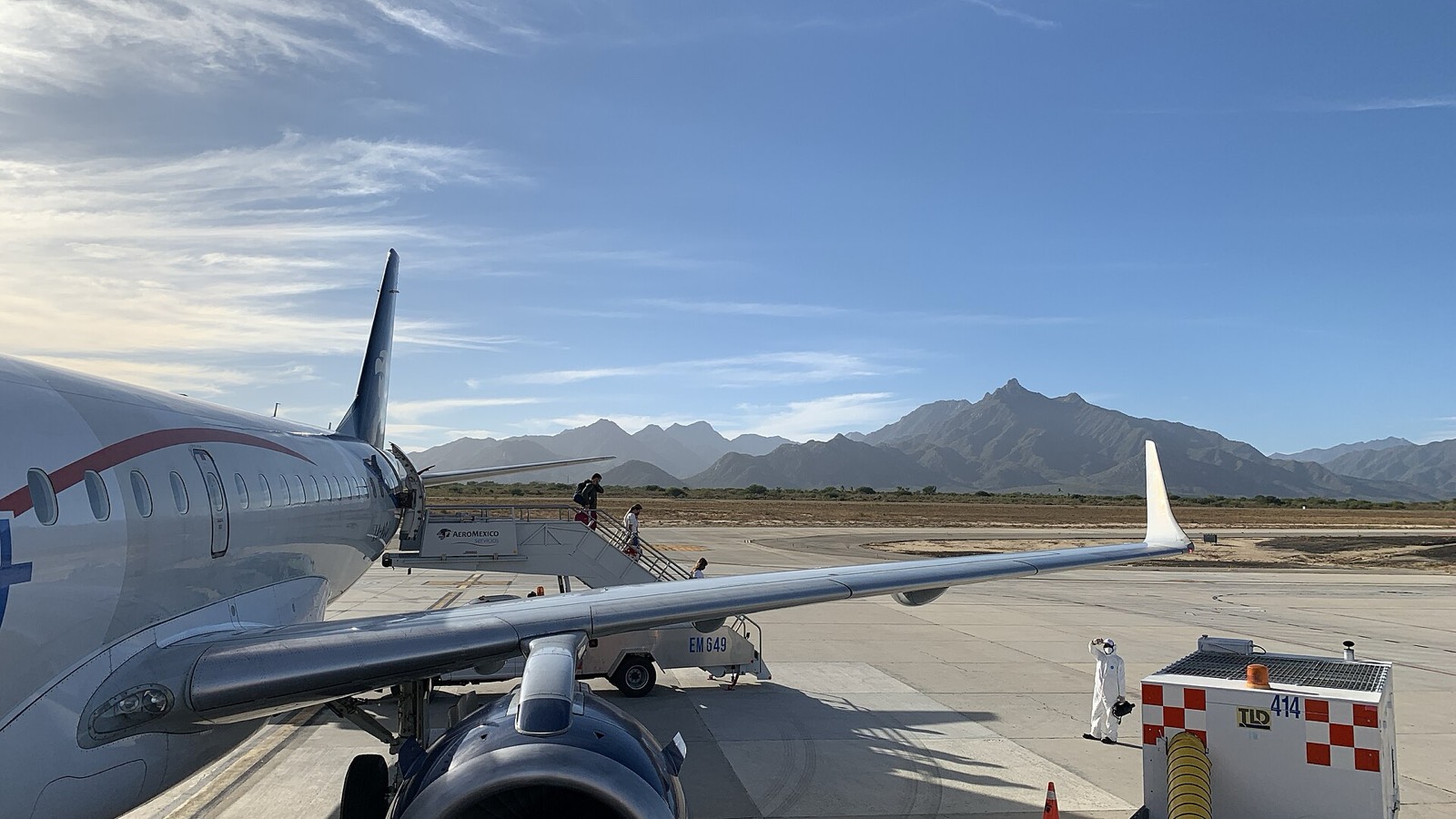 Jet parked on the tarmac at Los Cabos International Airport with desert mountains in the background