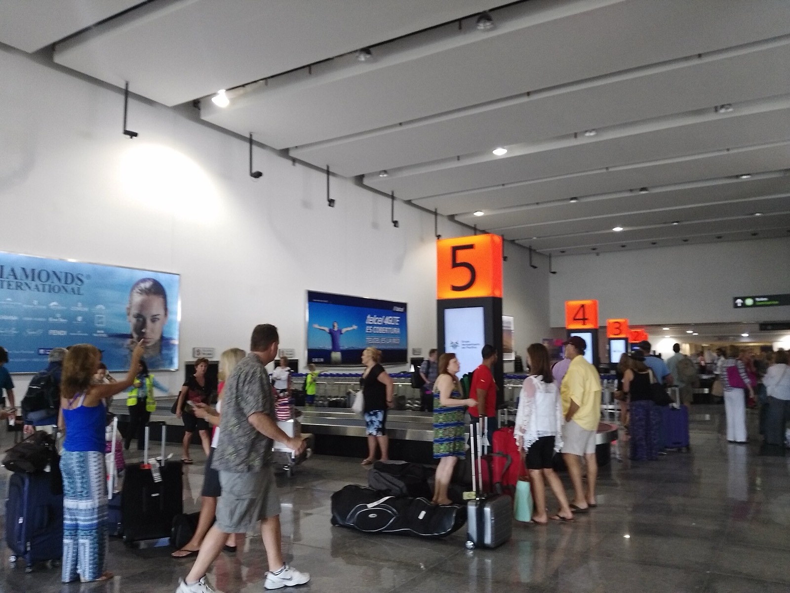Travelers collecting luggage at a baggage carousel inside Los Cabos International Airport