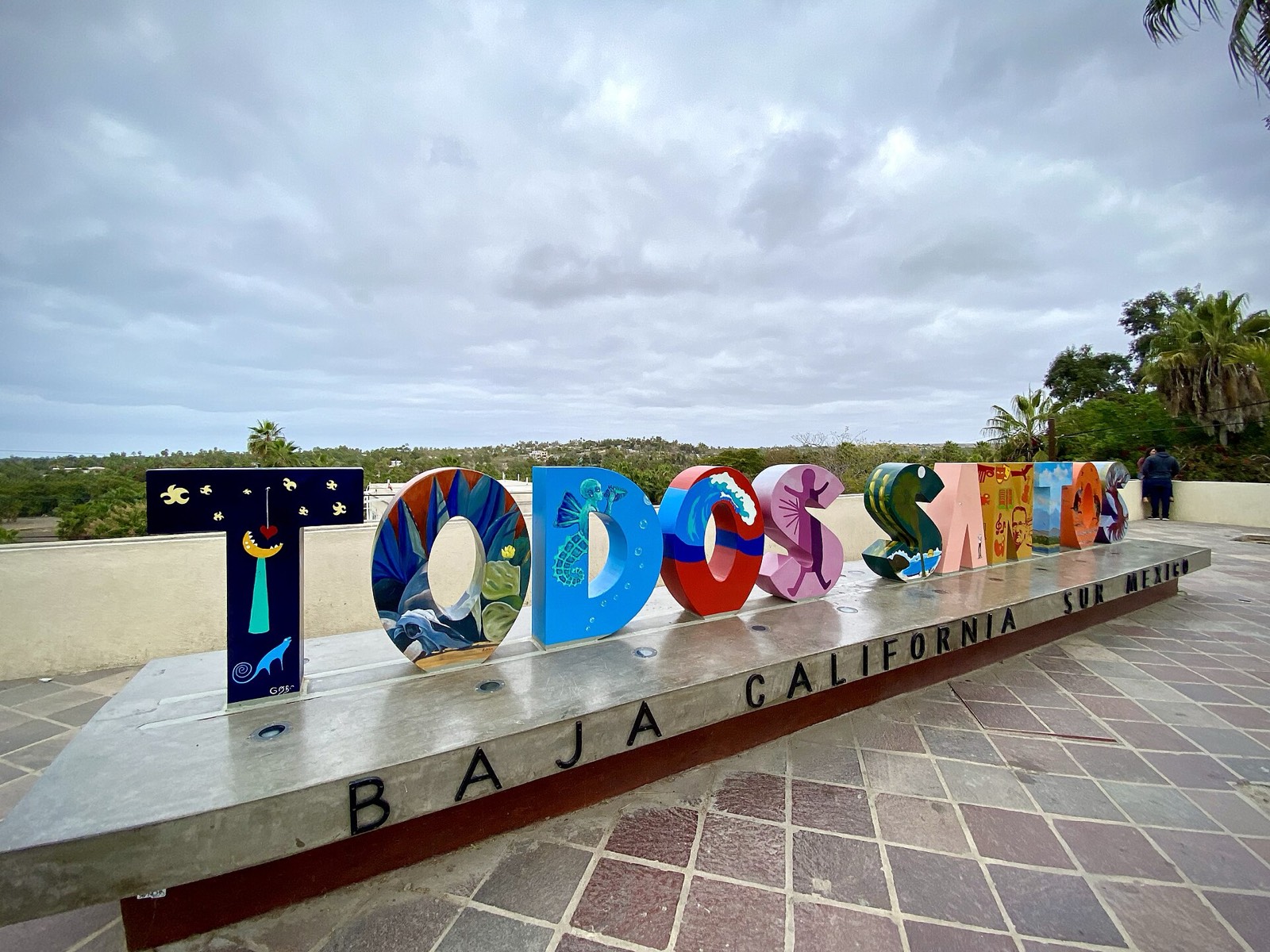 Colorful Todos Santos Baja California Sur letters on a tiled plaza under a cloudy sky