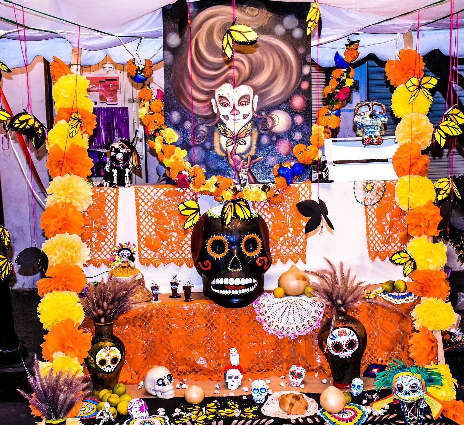 A Día de los Muertos altar decorated with marigolds, sugar skulls, and colorful papel picado